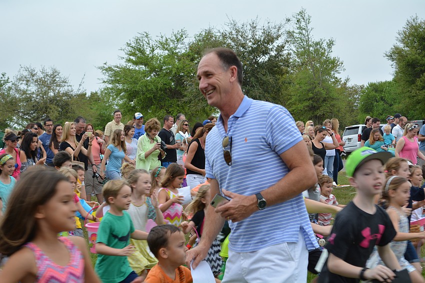 Children dash toward Easter eggs, darting around the Rev. Steve Price, after he gives the 