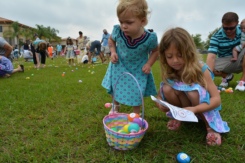 Vivien McMullen, 2, helps her sister, Keira, fill her basket.