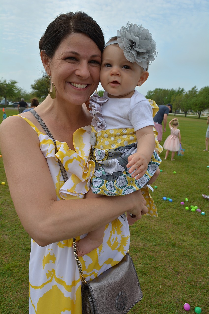 Julie and Madelyn Lazaris watch Madelyn's siblings, Andrew and Olivia, hunt for eggs.