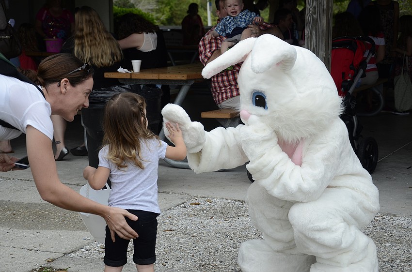 Hannah Miller of Sarasota gives the East bunny a high five...with a little encouragement from her mom, Diana. 