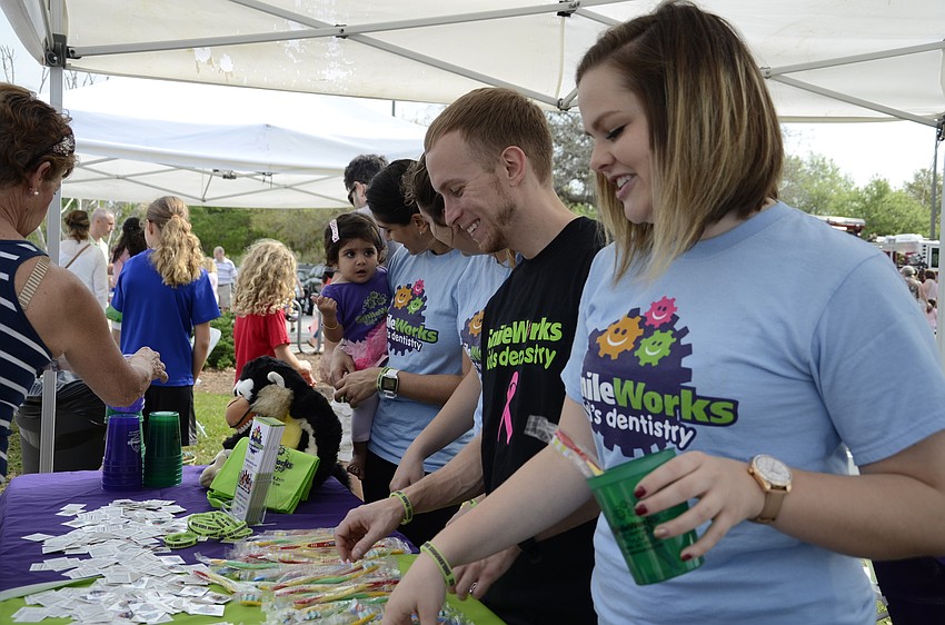 Bryan Mateer and Cassidy Gilley of Smile Works Dentistry give out free toothbrushes.