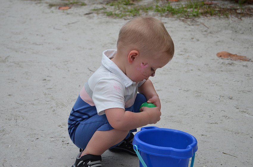 Camden Diskin is fixated on getting to the candy in his Easter egg.
