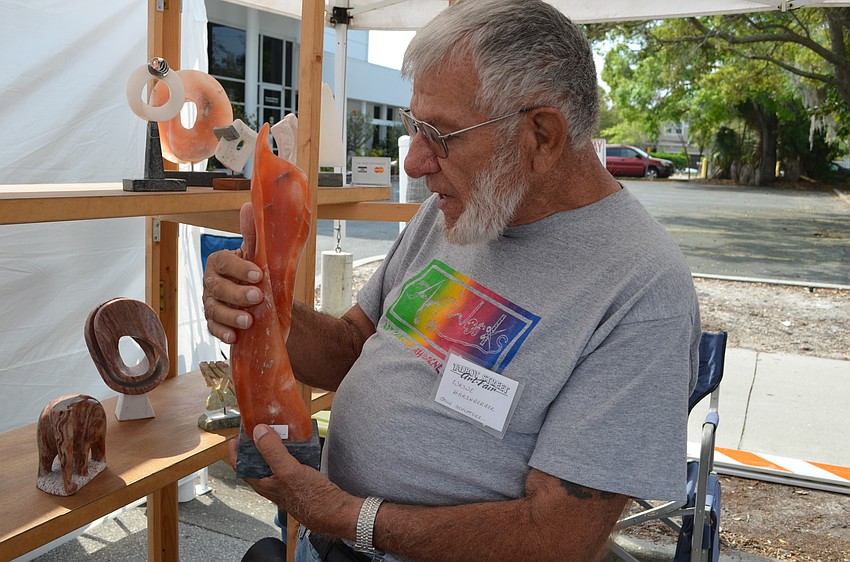 Artist Wayne Harshberger with one of his scultures carved from alabaster.