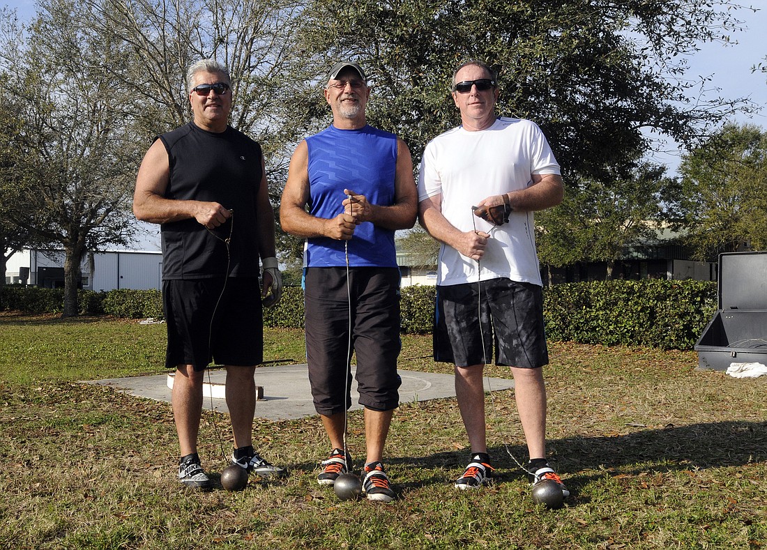 Sarasota residents Bob Arello and Gary Dixon train with Throws Florida Coach Andy Vince, center, in preparation for masters throwing competitions.