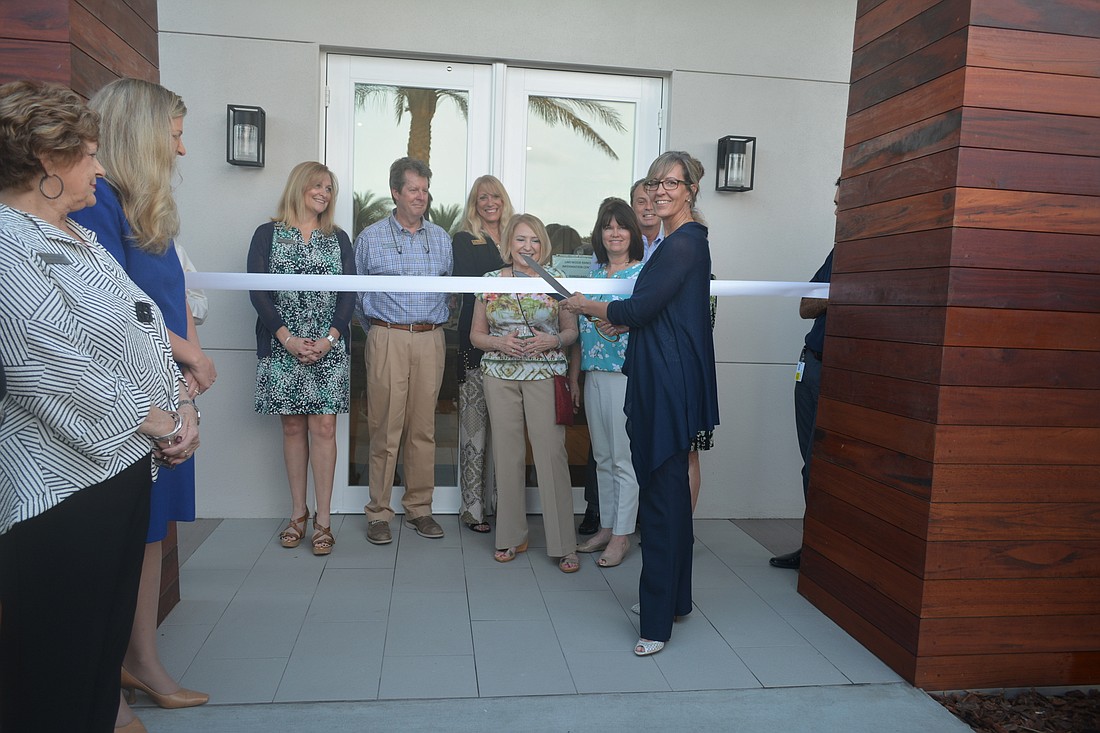 SMR's marketing director, Laura Cole, cuts a ribbon to the new information center with the help of Lakewood Ranch ambassadors.