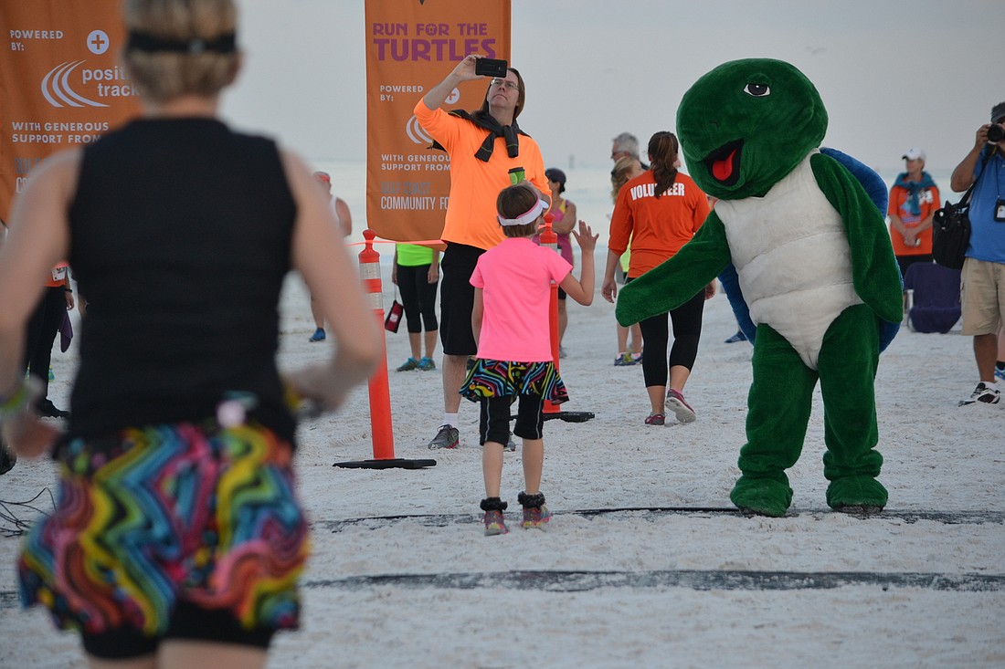 Shelly welcomes back runners from the one mile fun run during the Run for the Turtles on Saturday morning.