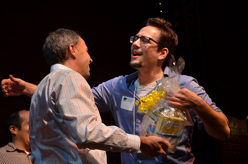 Sam Lowry congratulates YPG Spelling Bee winner Gavin Dietrich after awarding him with two pounds of honey as one of the prizes.