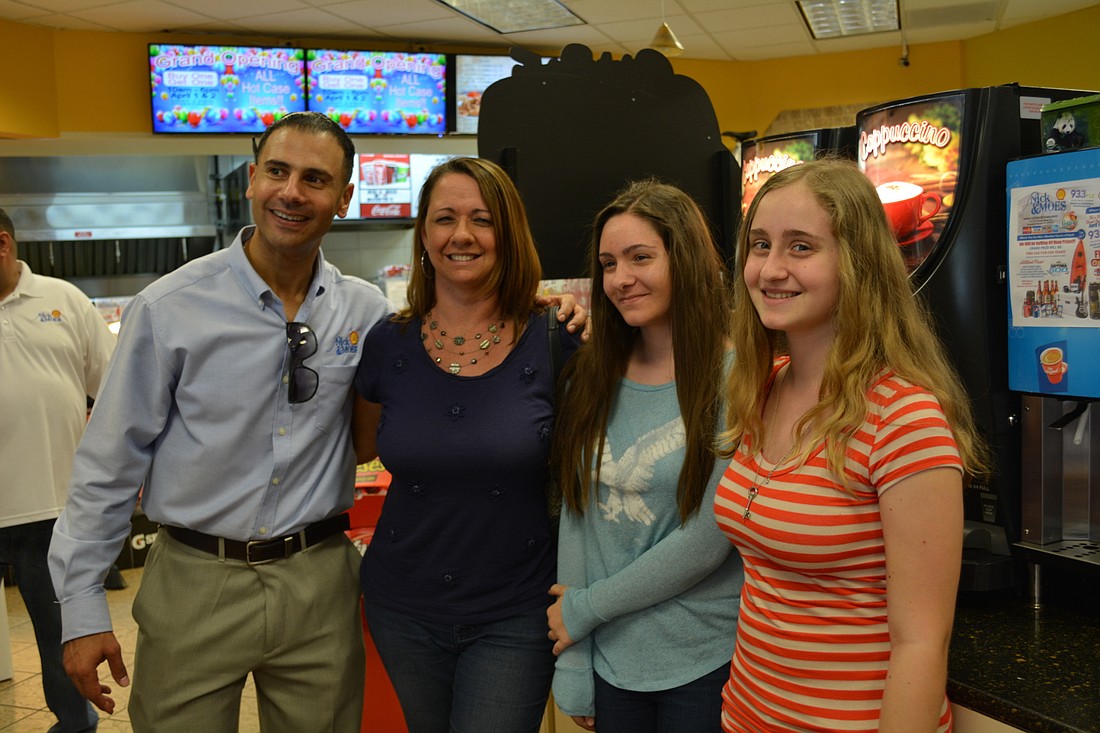 Nick and Moe's owner Nick Salem poses with Iris, Marissa and Amanda Boccarossa after their family wins pizza for a year.