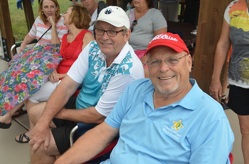 Casey Flynn and Mike Mayer, of East County, relax under the pavilion, away from the rain but close to the food and music.