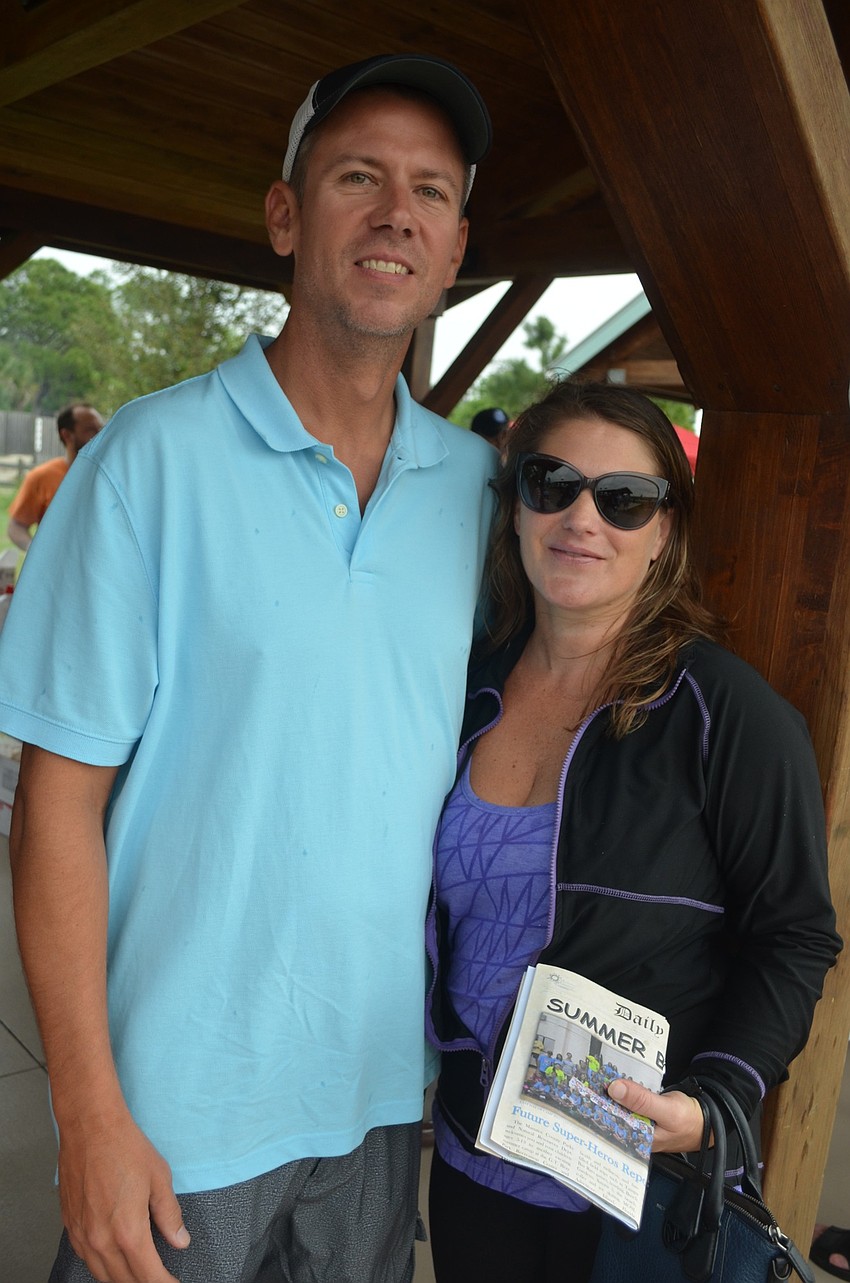 James Turk and his wife, Elyse, of Bradenton, take cover from the rain.