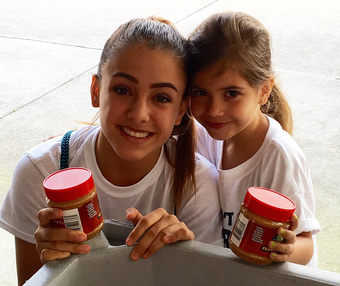 Jelly team students Sofia and Stella Mejicanos bring in their donations as part of Out-of-Door Academyâ€™s annual Peanut Butter and Jelly Food Drive Competition. Courtesy photo.