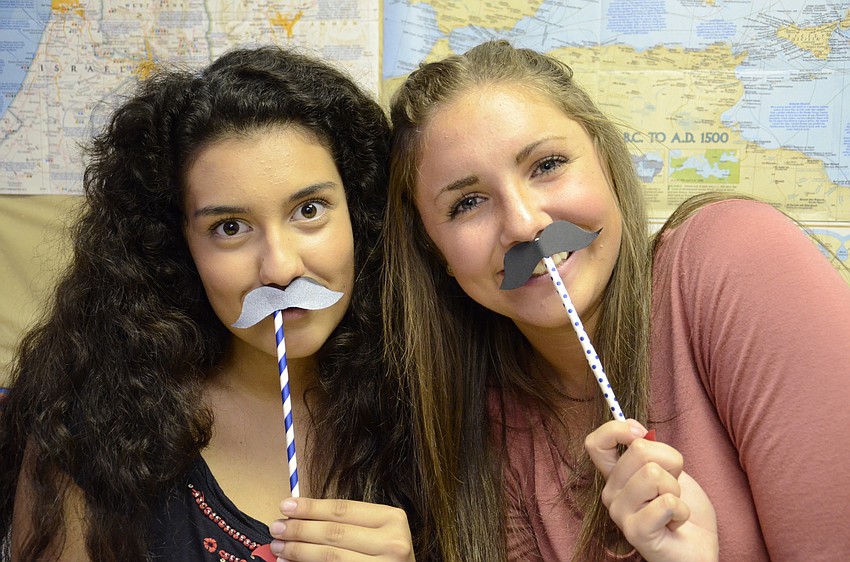 Jazmin Copeland and McKenzie West helped kids make mustache wands in the kids area.