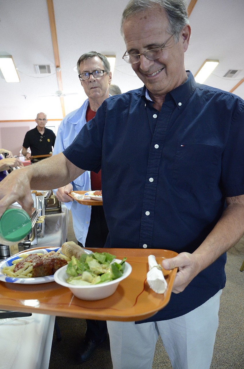 Ken Jordan adds a sprinkle of parmesan to his sauce.