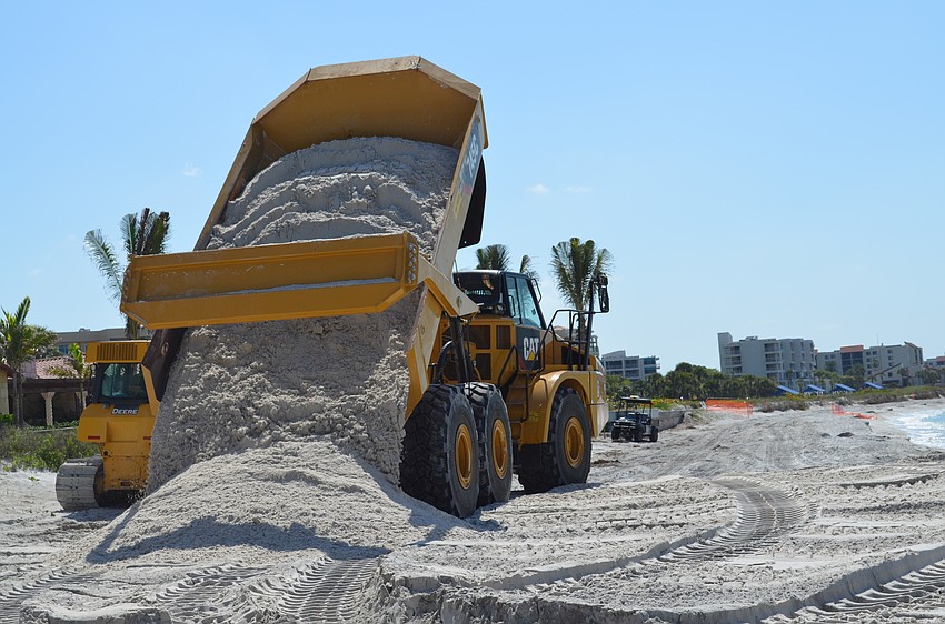 A dump truck unloads the second of thousands of loads of sand slated for the Longboat Key shoreline.