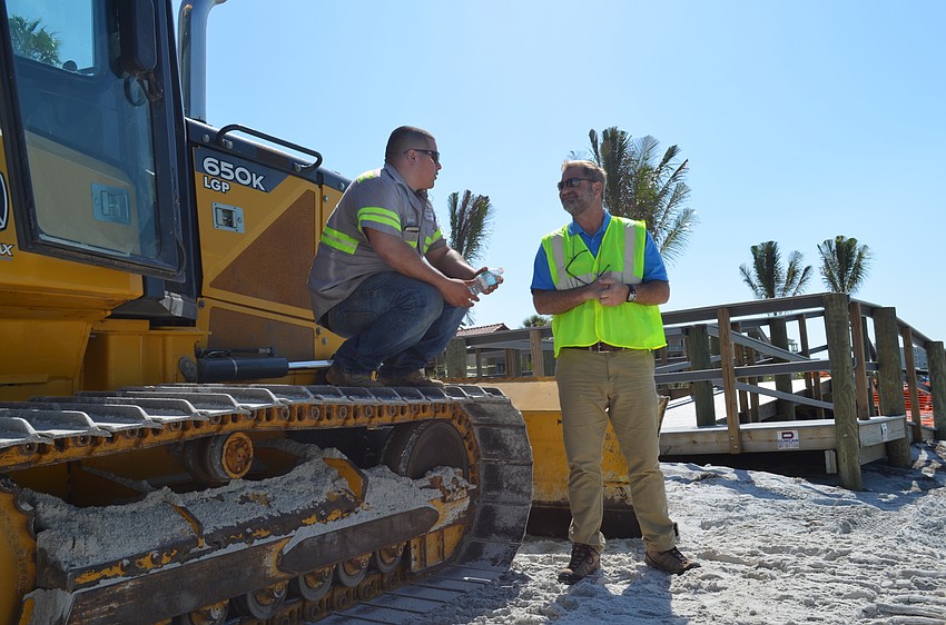 Contractor Alberto Benavides chats with Assistant Town Manager Michael Hein during a lull in activity.