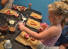 Lola Pond adds extra pink sprinkles to her doughnuts.