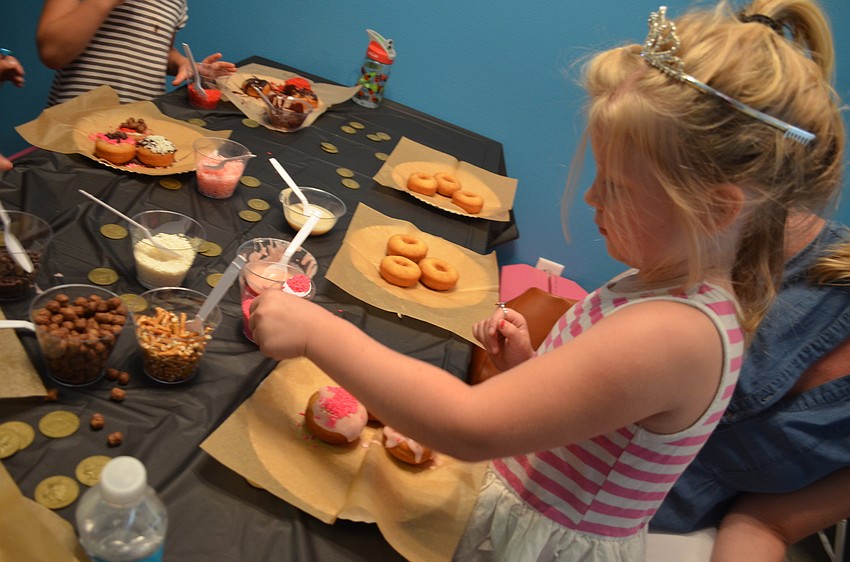 Lola Pond adds extra pink sprinkles to her doughnuts.
