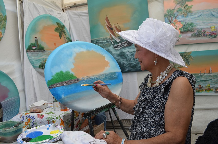 Kyung Ai Park paints for visitors at her booth during Siesta Fiesta.