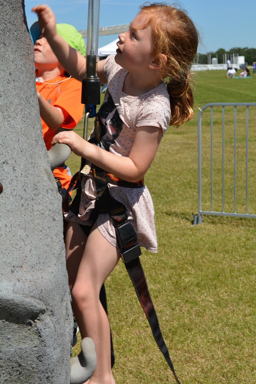 Dylan Grantham, 6, tests her skills on the rock climbing wall.