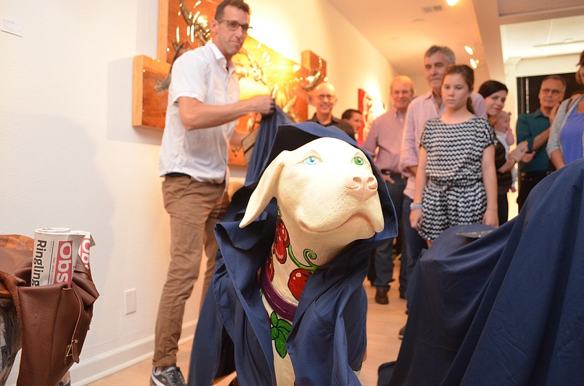 Artist Steen Strenk lifts the sheet to reveal 