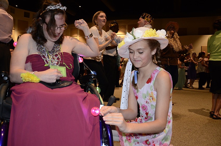 Lily Dunn, a Sarasota Military Academy student volunteer, decorates Jennifer Maurer of Lakewood Ranch's wheelchair with lights.