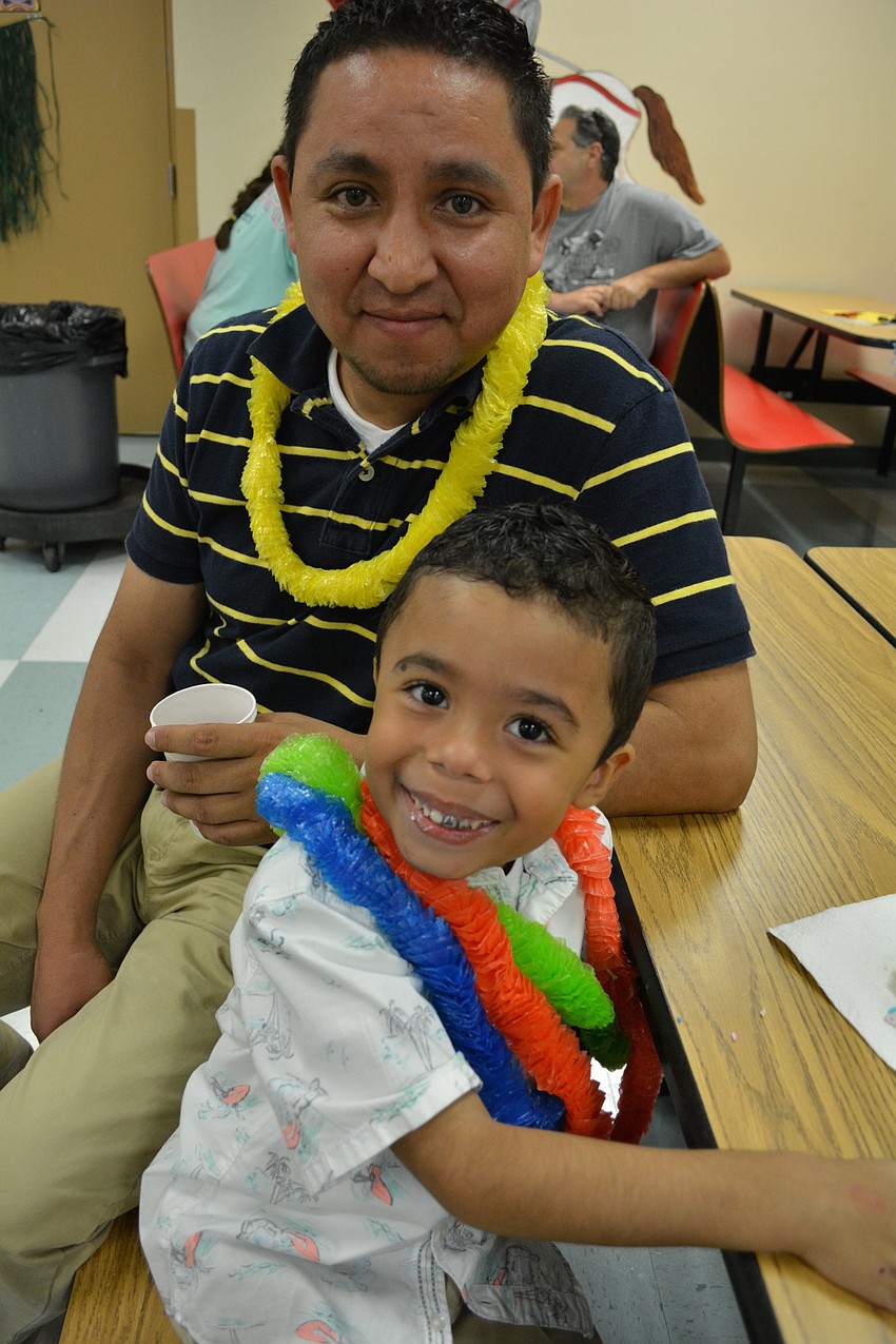 Omar Diaz and his step-son, Dominic Herrera, eat cookies.