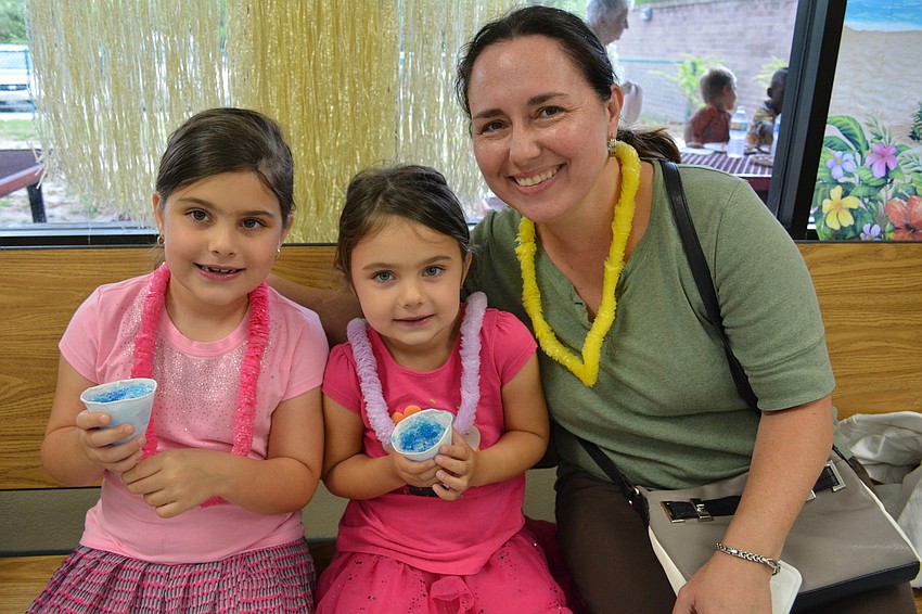 Hailey and Isabella Padgett have a bubble gum flavored snow cone with their mom, Alexandra.