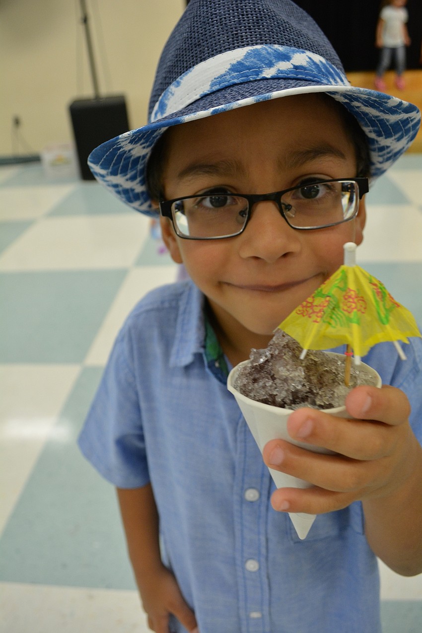 Victor Oliveira, 5, dresses up his snow cone with the night's theme.