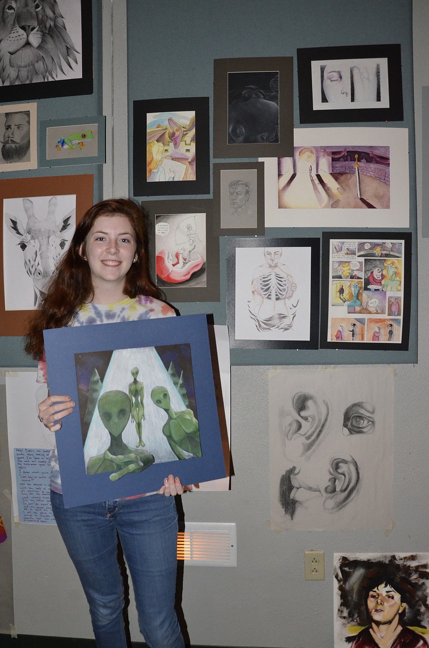 Senior Lauren Cash with her portfolio pieces. Cash's concentration for her fine arts class was depicting life-changing events in a woman's life.