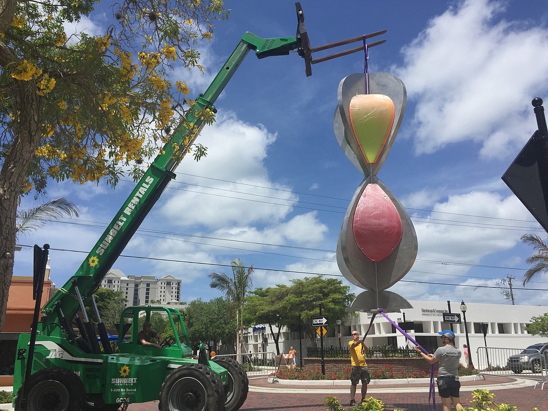 City staff works to install the sculpture Embracing Our Differences at the Main Street and Orange Avenue roundabout.
