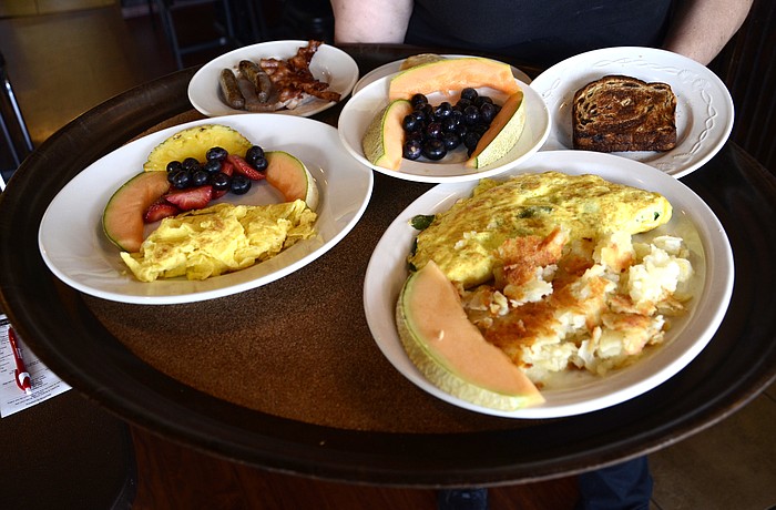 AnnMarie Miller of Bradenton serves up omelettes to a table. Chef Jason Pantelis includes a piece of fruit on every plate, which cleanses the palate, he said.