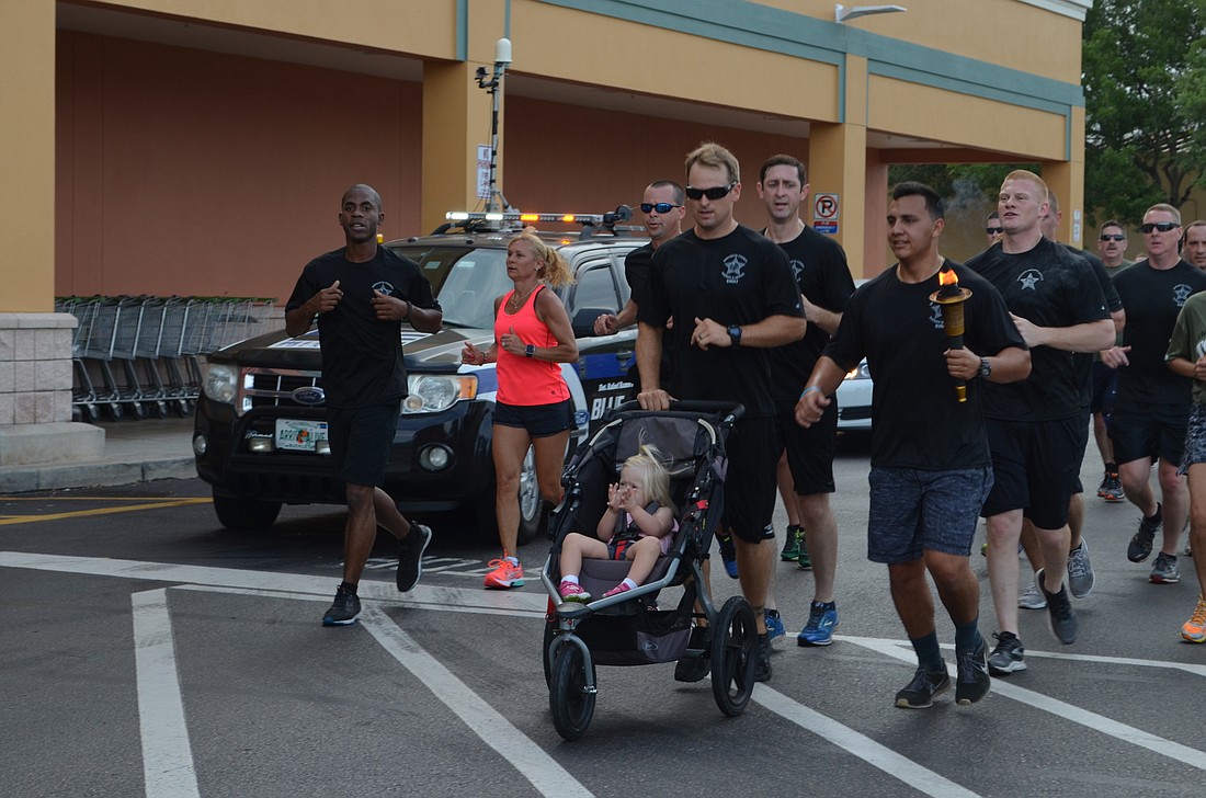 SWAT officer Ben Smith keeps up with runners with three-year-old daughter Bryleigh in a stroller.