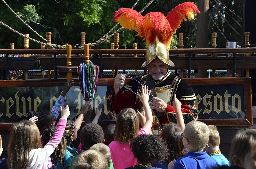 Bob Richardson hands out necklaces to eager Bashaw students.