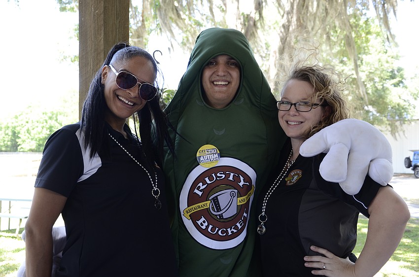 Katie Greenwood, Darian Abbas and Trish Houser of Rusty Bucket. Abbas is dressed like a pickle because it's the restaurant's signature addition to its meals.