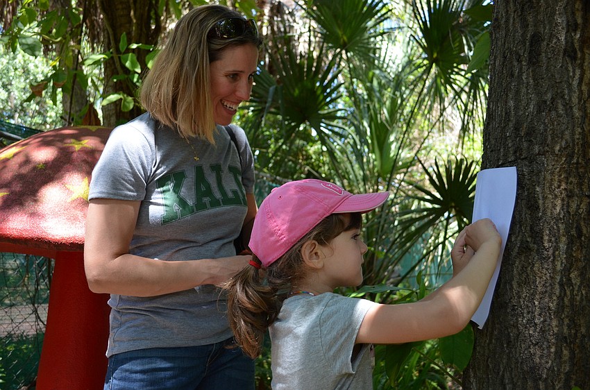 Kristin Papanickolas helps her daughter Lia trace the bark of a tree.