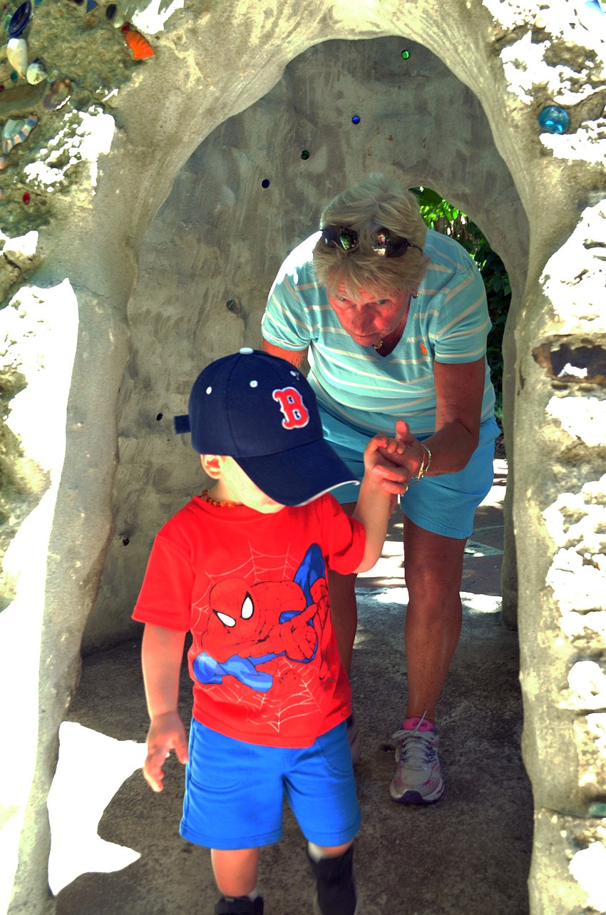 Mikey Papanickolas leads his grandmother Jane Heil through the garden.