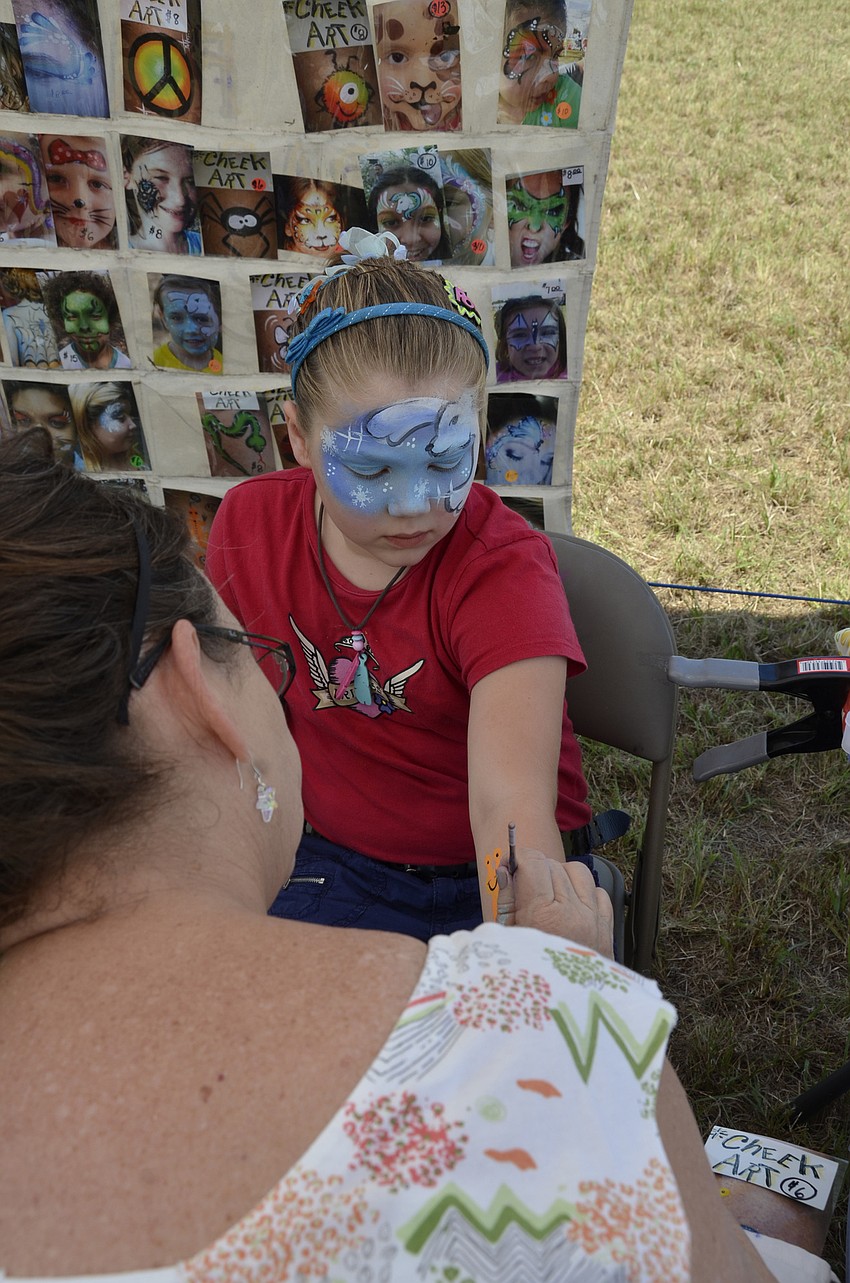 Reece Ehrhart of Palmetto gets a snail painted on her arm bu Melba Peel.