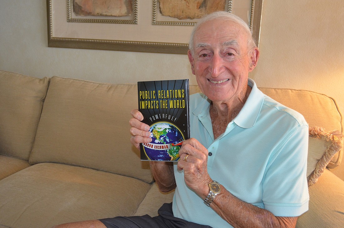Aaron Cushman with his book, "Public Relations Impacts the World," which was published in March.