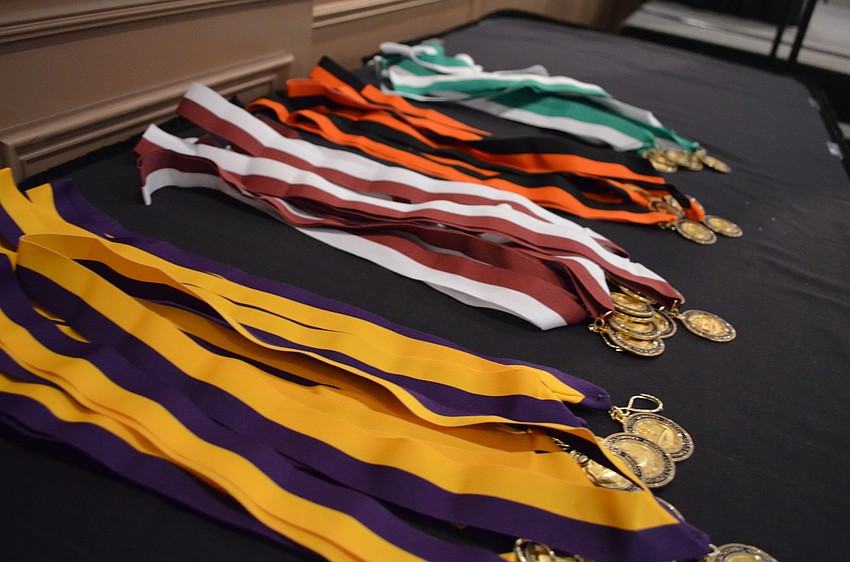 Students received medals with the colors that match their schools.