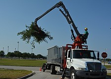 Tyson Green uses the self-loader truck to clean up trees on the Red Cross grounds in Lakewood Ranch.