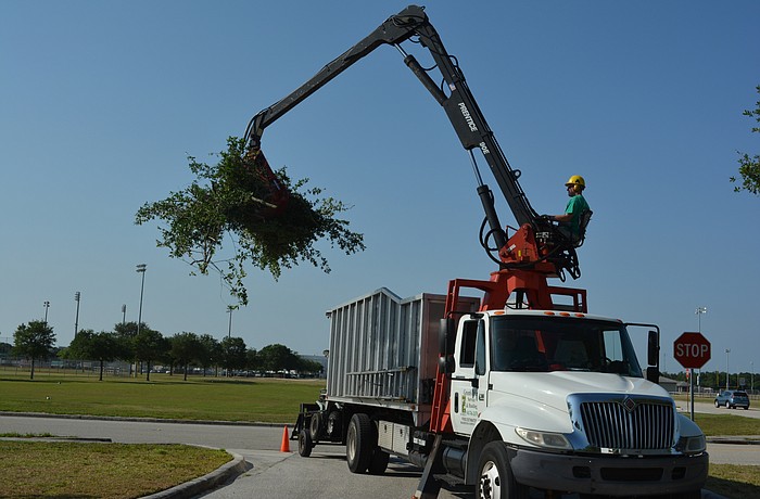 Tyson Green uses the self-loader truck to clean up trees on the Red Cross grounds in Lakewood Ranch.