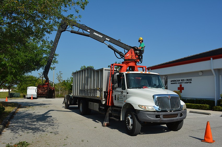Ken Green, shown working on the self-loader, and his son, Tyson, thought Arbor Day was the perfect time to donate their services to the Red Cross.