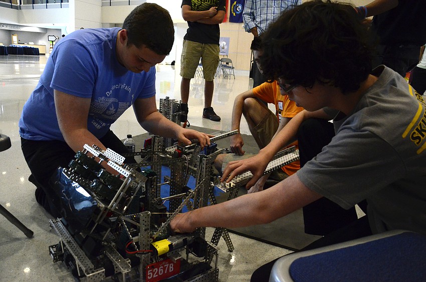 Pineview School student Jack Pullman and Braden River High School student Logan Miller work on the Skull and Bones Robotics team robot.
