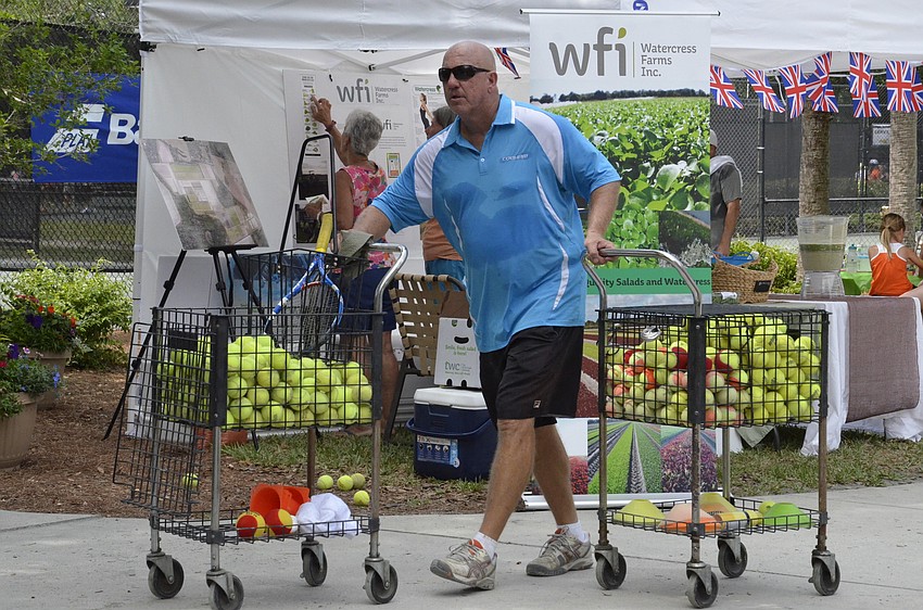 Greg Hill, junior tennis director, restocks the courts.