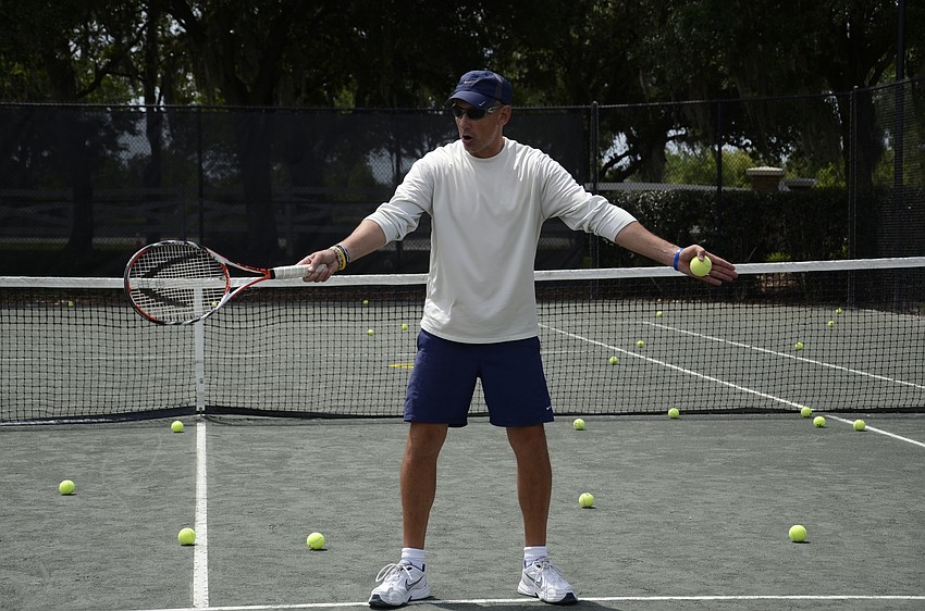 Matt Liverman, an instructor at Island Walk and Sandhill Preserve in Venice, coaches kids on their serve.