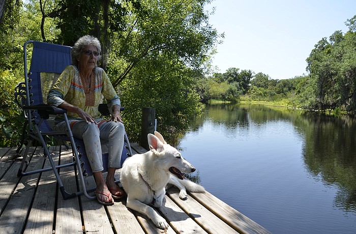 Peggy Christ and her German shepherd Nicky hang out on her riverside patio. Christ has lived on the Braden River for 30 years.