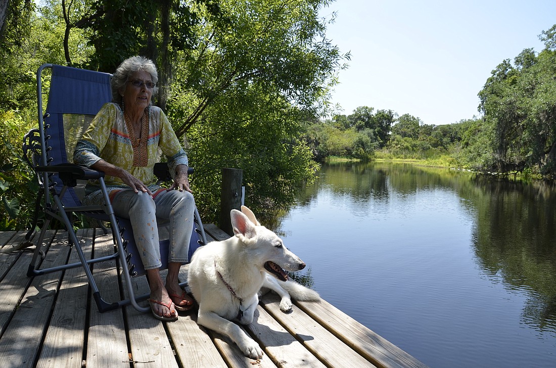 Peggy Christ and her German shepherd Nicky hang out on her riverside patio. Christ has lived on the Braden River for 30 years.