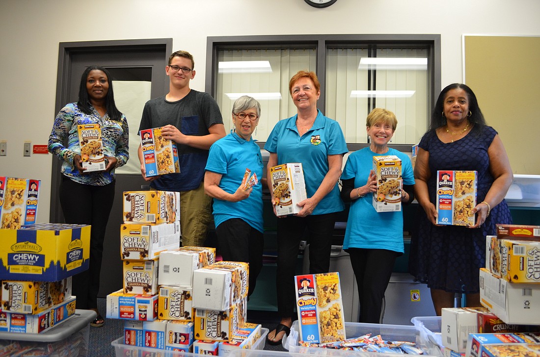 Booker Middle School Principal LaShawn Frost, Conor Andrich, Sharon Burde, Joyce McCoy, Susan Morin and S.Kay Daniels with the 6,000 granola bars donated to the school Wednesday.