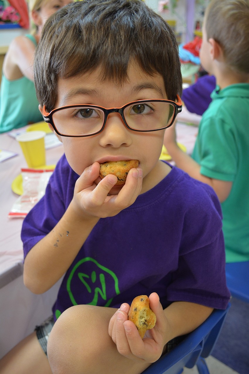 Thomas Palatino, 5, munches on muffins across the table from his mom, Maria.