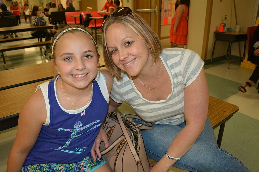 Emma Barnes, a fourth-grader, makes sure to show her mom, Becca, her featured artwork.